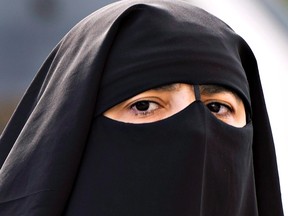 In this file photo, a woman wears a niqab as she walks in Montreal. (Canadian Press)