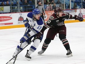 Michael Pezzetta, left, of the Sudbury Wolves, and Declan Chisholm, of the Peterborough Petes, battle for position during OHL action at the Sudbury Community Arena in Sudbury, Ont. on Friday November 24, 2017. John Lappa/Sudbury Star/Postmedia Network