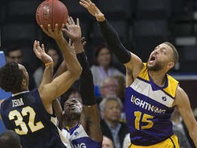 London Lightning?s Garrett Williamson puts his all into blocking a shot by Mareik Isom of the Saint John Riptide during their National Basketball League of Canada game at Budweiser Gardens on Thursday night. The Riptide won 105-100. (DEREK RUTTAN, The London Free Press)