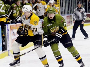 Sarnia Sting's Curtis Egert (23) and North Bay Battalion's Kurtis Evans (14) battle for the puck in the first period at Progressive Auto Sales Arena in Sarnia, Ont., on Friday, Dec. 1, 2017. (Mark Malone/Postmedia Network)
