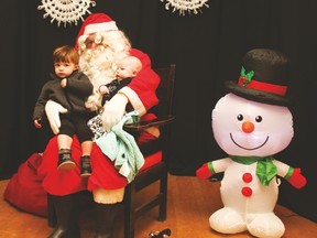 Umscheid brothers Tor, 2, left, and Wolfgang, 4 months, sit on Santa’s lap for a picture.