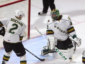 Joseph Raaymakers of the Knights looks behind him as he loses sight of the puck at his pads with Evan Bouchard on hand in the first period of their game Friday against the Oshawa Generals in Budweiser Gardens. (Mike Hensen/The London Free Press)