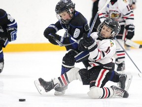 Mason Walker of the Copper Cliff Redmen battles for the puck with Grady Jalbert of the Nickel City Jr. Sons during minor atom AA championship game action at the Sudbury Regional Silver Stick Tournament in Sudbury, Ont. on Sunday December 3, 2017. Gino Donato/Sudbury Star/Postmedia Network