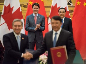 Canadian Prime Minister Justin Trudeau, rear left, and Chinese Premier Li Keqiang, rear right, applaud during a signing ceremony at the Great Hall of the People in Beijing Monday, Dec. 4, 2017. (Fred Dufour/Pool Photo via AP)