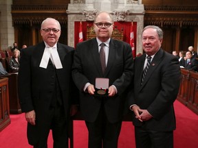 Kevin McCormick (centre), president and vice-chancellor of Huntington University, has received the Senate of Canada 150 Medal. Senator Jim Munson presented the award during a ceremony in Ottawa. The medal was designed by Lt.-Col. Carl Gauthier, Director of Honours & Recognition at the Department of National Defence.