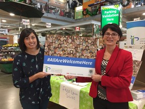 Volunteer Katy Boychuk and Jill Tansley, co-chair of the London & Middlesex Local Immigration Partnership, show off some of the 1,000 lawn signs given away to residents and businesses to support an inclusive, welcoming community. (JANE SIMS, The London Free Press)