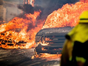 Flames consume vehicles as a wildfire rages in Ventura, Calif., on Tuesday, Dec. 5, 2017. (AP Photo/Noah Berger)