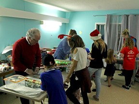 After picking out gifts for mom and dad, children can get their gifts wrapped on site by one of the dozens of volunteers.  - Photo by Keenan Sorokan