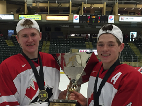 Former Spruce Grove Saint Ian Mitchell (right) and current Saint Jarrod Gourley (left) hold the World U-17 Hockey Challenge trophy in 2015. Gourley and teammate T.J. Lloyd have been selected for Team Canada West in the 2017 World Junior A Challenge taking place in Turo, N.S. from Dec. 10-16. - Photo submitted