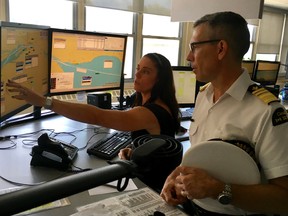 Canadian Coast Guard marine communications and vessel traffic services officer Julie MacRae of Sarnia shows Coast Guard Commissioner Jeffery Hutchinson technology used keep ships moving safely and efficiently on the Great Lakes.  The coast guard is recruiting officers for its marine communication centres, and offering testing for those interested Dec. 12 and 13 in Sarnia. (Handout)