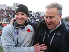 Western Mustangs defensive co-ordinator Paul Gleason celebrates with head coach Greg Marshall after winning the Yates Cup. Winning the Vanier Cup makes recruiting both easier and more difficult, Marshall says. (MIKE HENSEN, The London Free Press)
