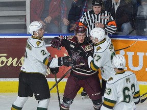 Peterborough forward Chad Denault mixes it up with London Knight Evan Bouchard, left, and Robert Thomas at the end of the first period of their OHL game played at Budweiser Gardens in London on Friday December 8, 2017. (MORRIS LAMONT, The London Free Press)