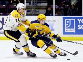 Sarnia Sting's Marko Jakovljevic, left, hooks Erie Otters' Emmett Sproule in the second period at Progressive Auto Sales Arena in Sarnia, Ont., on Friday, Dec. 8, 2017. (MARK MALONE/Postmedia Network)