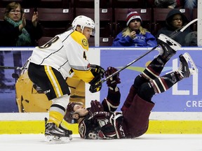 Sarnia Sting's Alexandre Hogue, left, knocks down Peterborough Petes' Matt McNamara in the second period at Progressive Auto Sales Arena in Sarnia, Ont., on Saturday, Dec. 9, 2017. (MARK MALONE/Postmedia Network)