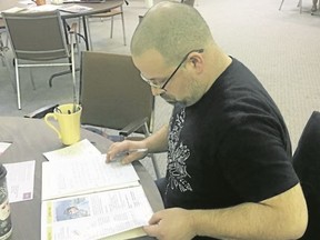 BRUCE BELL/THE INTELLIGENCER
Darren Moore of Belleville prepares a letter for a political prisoner during Write for Rights at Bridge Street United Church on Sunday afternoon. The event was hosted by Amnesty International Group III Belleville.