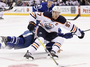 Edmonton Oilers centre Connor McDavid (97) drives to the net past sprawling Toronto Maple Leafs defenceman Ron Hainsey (2) during first period NHL hockey action in Toronto on Sunday, December 10, 2017. THE CANADIAN PRESS/Frank Gunn