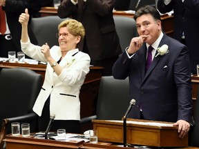 Ontario Finance Minister Charles Sousa, right, and Premier Kathleen Wynne get a standing ovation after announcing free universal health care to everyone over the age of 24 as part of the 2017 Ontario budget at Queen's Park in Toronto on Thursday, April 27, 2017. THE CANADIAN PRESS/Nathan Denette