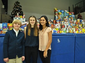 St. Catherine Catholic Elementary School Grade 7 students Ryan Tetreault, Sofia Makinen and Samantha Lauzon are shown in the school's gymnasium in front of the goods the school collected to donate to Outreach for Hunger. Students brought in over 11,000 items over a two-week period.