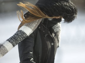 Rama Asadi of Hamilton disappears into her hood and scarf as she walks to Western's main campus into a cold northwest wind on Tuesday December 12, 2017. (MIKE HENSEN, The London Free Press)