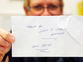 Luke Hendry/The Intelligencer
Christmas Sharing program co-ordinator Pam Smith holds a donor's grateful envelope at the program office in Belleville. A man who'd registered to receive aid returned the next day to contribute after a sudden change in finances.