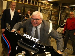 Jason Miller/The Intelligencer
Local businessman and philanthropist Ross McDougall hops into the saddle of this Harley Davidson motorcycle, donated to city police by himself, Mark Hanley (first from left), Peter Smith (right) and Dennis McCullough.