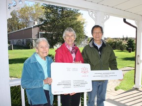 Marian Hindmarsh, Susan and Chuck Chan hold the awarded sign: “In recognition and appreciation of Habitat Conservation efforts on this Property”. (Contributed photo)