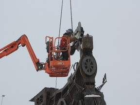 Local artist Scott McKay worked all day Friday to install the landmark sculpture in the centre of the Gateway roundabout. McKay, a millwright by trade, worked for many months creating a curving train made out of steel that includes a steam locomotive, a coal car, a passenger car and a caboose. (Laura Broadley/Times-Journal)