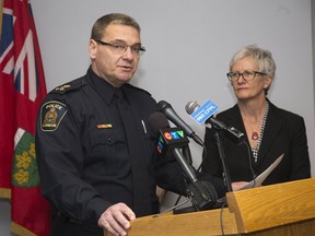 London police Chief John Pare reads a prepared statement about a rash of criminal charges against city police officers as London Police Services Board chairperson Jeannette Eberhard looks on during a hastily arranged news conference at police headquarters Friday. (DEREK RUTTAN, The London Free Press)