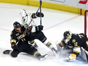 Sarnia Sting's Cameron Hough (11) is called for hooking London Knights' Tyler Rollo (13) in front of Sting goaltender Justin Fazio on Friday at Budweiser Gardens in London. MIKE HENSEN/Postmedia Network