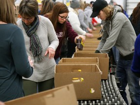 Tim Miller/The Intelligencer
Volunteers with the Christmas Sharing program pack boxes full of food to be delivered to families in need on Sunday at the JDS Express warehouse in Belleville.