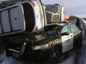 An Ontario Provincial Police cruiser is destroyed after a transport truck lost control near Belleville on Saturday and a vehicle being hauled on the transport landed on the car. The officer was not injured. (Ontario Provincial Police/Supplied Photo)