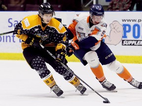 Sarnia Sting's Braden Henderson (6) is chased by Flint Firebirds' Jack Phibbs (9) in the second period at Progressive Auto Sales Arena in Sarnia, Ont., on Saturday, Dec. 16, 2017. The Sting wore special jerseys on their third annual ugly Christmas sweater night. (Mark Malone/Postmedia Network)