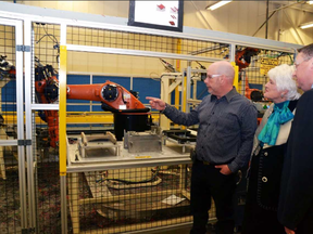During a Monday tour of C.R. Plastic Products Inc. in Stratford, Brad Girvin, the plant's engineering/maintenance and facilities manager, shows Guelph MPP Liz Sandals and Stratford Mayor Dan Mathieson their new proprietary robotic assembly line. Galen Simmons/The Beacon Herald/Postmedia Network