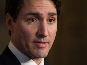 Prime Minister Justin Trudeau speaks with the media in the foyer of the House of Commons following the release of an ethics report in Ottawa on Wednesday December 20, 2017. (THE CANADIAN PRESS/Adrian Wyld)