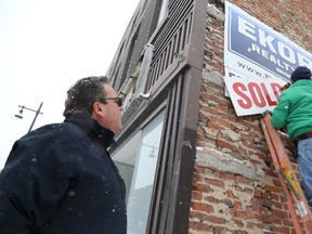 Jason Miller/The Intelligencer
Steve Fedora (right) installs a sold sign on the former China Gate property sold by Jamie Troke's  (left) firm, Ekort Realty.