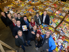 Participants in the London Business Cares Food Drive stand in front of some of the 325,000-plus pounds of food donated to the London Food Bank with the effort's director Wayne Dunn, top right, on Friday December 22, 2017. MORRIS LAMONT/THE LONDON FREE PRESS /POSTMEDIA NETWORK