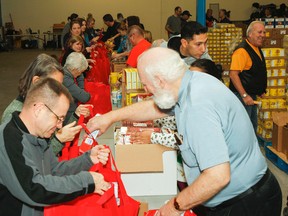 Salvation Army Christmas Hampers campaign volunteers pack up food at the Frontenac Mall earlier this week. (Julia McKay/The Whig-Standard)