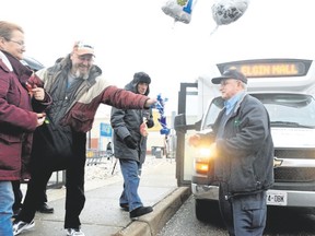 Transit driver Murray Medhurst, right, is congratulated by members of his family and the public outside the Walmart parking lot in St. Thomas. Medhurst retired Friday after a career spanning five decades in St. Thomas. (LOUIS PIN, Times-Journal)