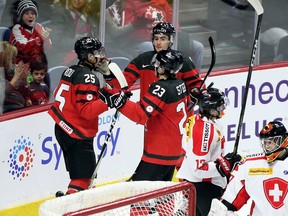 Canada's Jordan Kyrou (25) of the Sarnia Sting celebrates his first-period goal with teammates Sam Steel (23) and Dillon Dube (9) during an 8-1 win over Switzerland in a pre-tournament exhibition game for the world junior hockey championship in Hamilton, Ont., on Friday, Dec. 22, 2017. (PETER POWER/The Canadian Press)