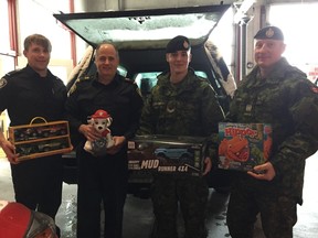 London firefighter Josh Clark, left, and Captain Dave Hubbell help Toys for Tots Canada volunteers Cpl. Marc Buttazzoni and Master Warrant Officer Rob Krizanec load up presents for children in need Saturday morning. (Jennifer Bieman/The London Free Press)