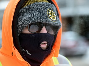 Reanne Cruickshank is bundled up against the cold weather while walking on Dundas Street on Boxing Day. London residents are being warned to stay indoors where it?s warm by weather authorities. (MORRIS LAMONT, The London Free Press)