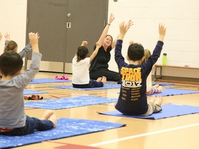 Tarryn Cothill teaches yoga to a senior kindergarten/Grade 1 class at Holy Cross Catholic Elementary School on Dec. 20. (Gino Donato/Sudbury Star)