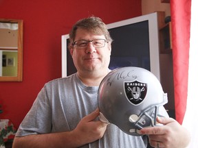 NFL super fan Robert Shlemkevich with an autographed helmet at his home in Sudbury, Ont. on Thursday December 21, 2017. Gino Donato/Sudbury Star/Postmedia Network
