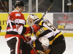 Ottawa 67's forward Kody Clark pushes Kingston Frontenacs defenceman Emmett Gordon into Frontenacs goaltender Jeremy Helvig during the first period of their Ontario Hockey League game in Kingston, Ont., on Thursday, Dec. 28, 2017. (Elliot Ferguson/The Whig-Standard/Postmedia Network)