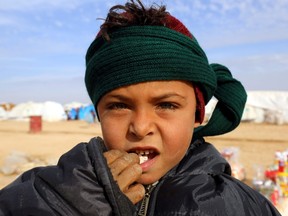 DELIL SOULEIMAN/Getty Images
A displaced Syrian child, who was forced to leave his hometown by the war against the Islamic State (IS) group, looks into the camera at the Ain Issa camp on Dec. 18. As temperatures drop, tens of thousands of civilians forced out of their homes by Syria’s war are spending yet another winter in flimsy plastic tents or abandoned half-finished buildings. And without heating, blankets and warm clothes, or access to proper medical care, even a simple cold can turn deadly.