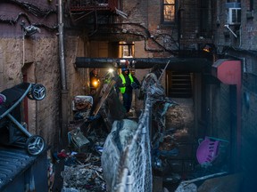 Police and workers inspect the building Friday, Dec. 29, 2017, where more than 10 people died in a fire in the Bronx borough of New York. (AP Photo/Andres Kudacki)