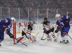 Canada?s Carter Hart makes a pad save on Brady Tkachuk of the United States as defenceman Victor Mete, a former London Knight, and American attacker Joey Anderson close in during the second period of Friday?s much-anticipated first meeting of the perennial rivals in world junior hockey round-robin outdoor action at New Era Field in Orchard Park, N.Y., Friday.  Tied 3-3 after overtime, Canada?s top guns went as cold as the snowy, sub-zero conditions and the U.S. notched a 4-3 shootout win. (Mark Blinch/The Canadian Press)