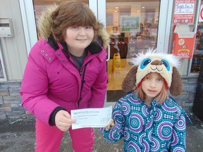 Submitted Photo
Carly Land, 12, and Payton Oliver, 8, hold a donation cheque for the Children's Cancer Fund at Kingston General Hospital while standing in front of the Shannonville-based business, Fast Freddy's. The business was one of several in the area which helped Land raise the funds.