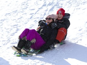 Asha Rogers and her nine-year-old stepson Gavin McIlwain speed down a snow covered hill in Basil Grover Park in London. (DEREK RUTTAN, The London Free Press)