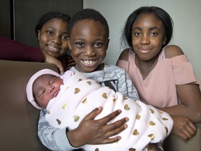 Shaikeilia Hare (12), Akeem Varfee (6) and Siennah Jabba (12) with their new sister, Leila Elizabeth Hare, at Victoria Hospital in London, Ont. on Monday. Leila is London's first baby of 2018. She arrived at 12:20 am and weighed in at 8 pounds, 15 ounces. (DEREK RUTTAN, The London Free Press)